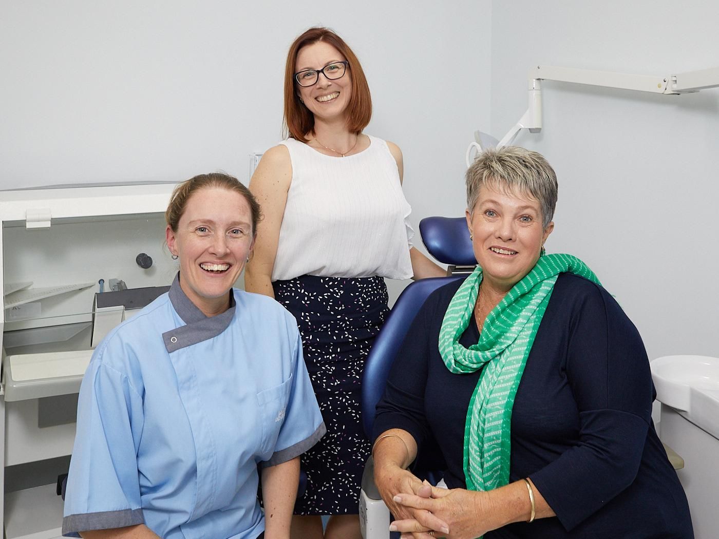 Three Women Are Posing for a Picture in a Dental Office — Bromley's Denture Clinic in Tweed Heads South, NSW