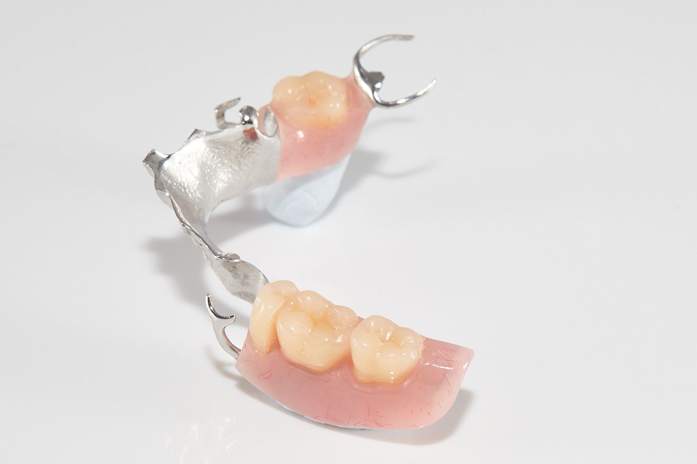A Close Up of a Partial Denture on a White Surface — Bromley's Denture Clinic in Tweed Heads South, NSW