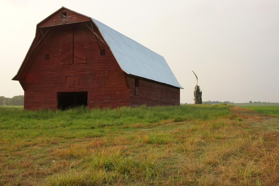 a barn in the middle of the field