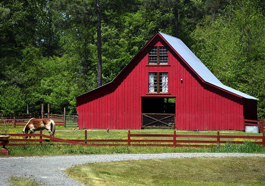 a color red barn with horse on the side