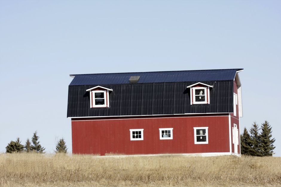 a house barn in the middle of the field