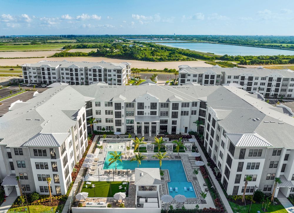 An aerial view of a large apartment building with a large pool in the middle.