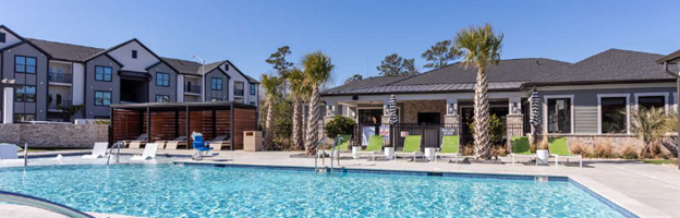 There is a large swimming pool in front of a building.
