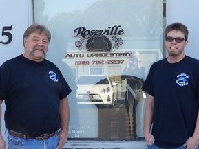 two men are standing in front of a window that says roseville auto upholstery