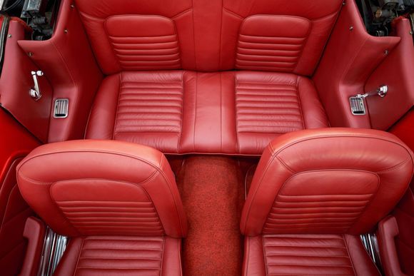 the back seat of a red car with red leather seats