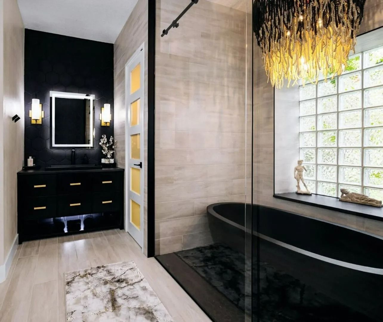 A bathroom with a black tub and a chandelier hanging from the ceiling