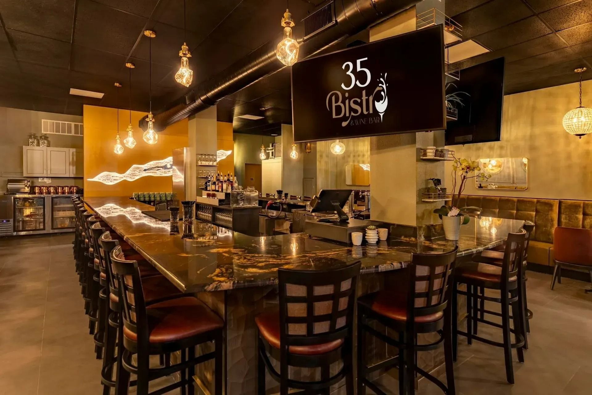 A restaurant with a long bar and lots of chairs. A restaurant with a long bar and lots of chairs.