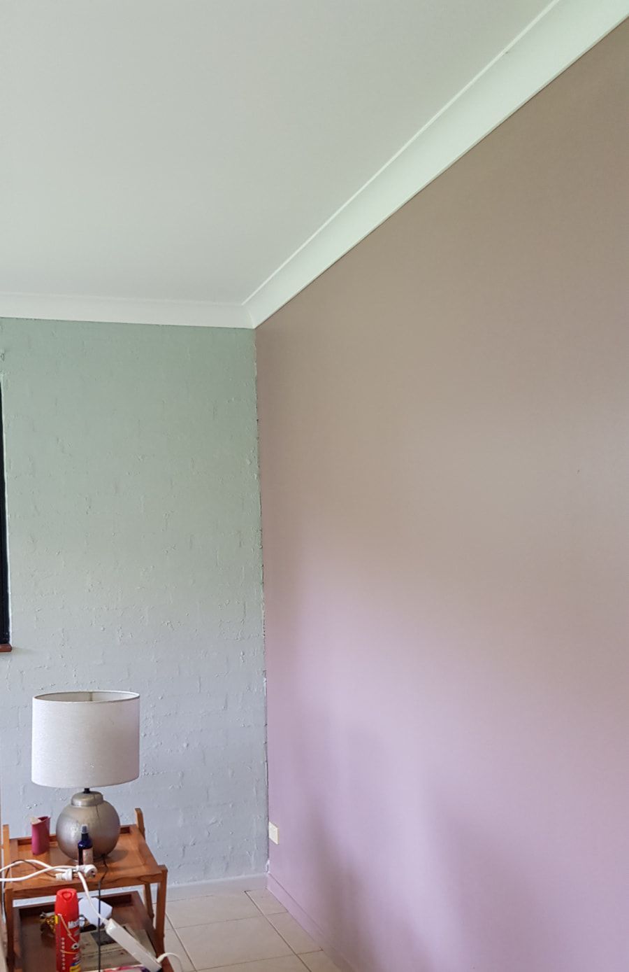 A living room with two walls painted different colors and a lamp on a table — Axis Painting in Coffs Harbour, NSW