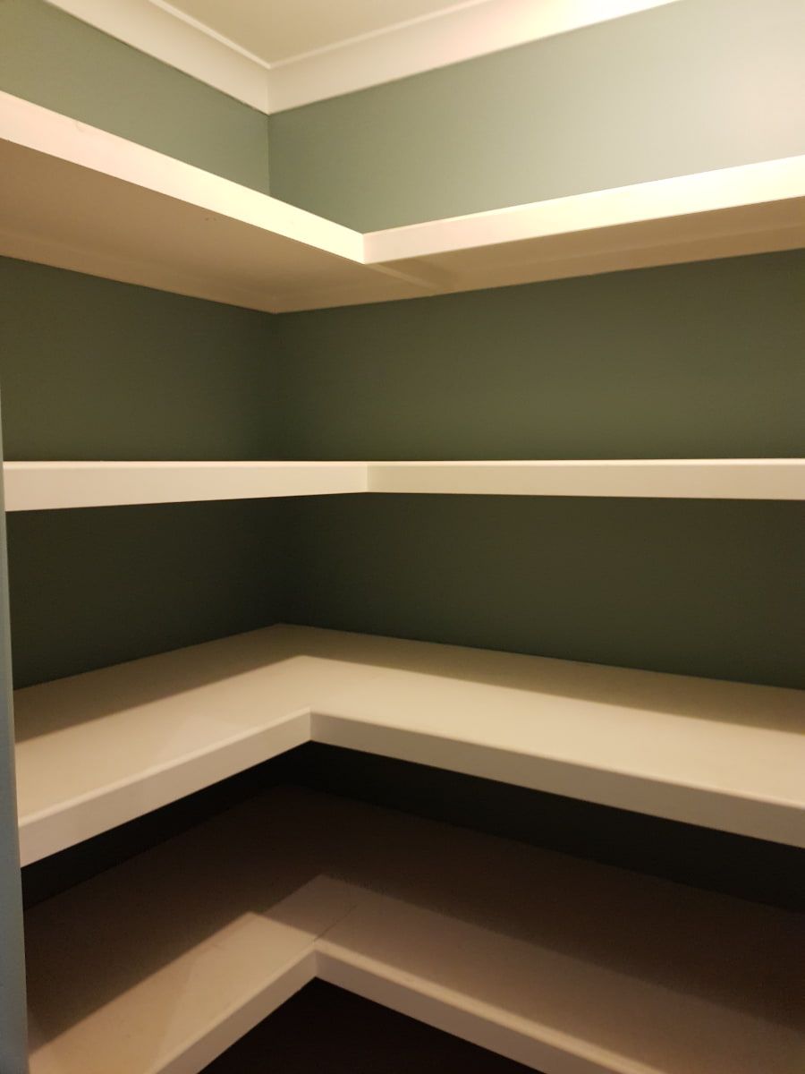 A room with a lot of shelves and a green wall — Axis Painting in Coffs Harbour, NSW