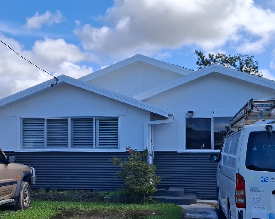 A white van is parked in front of a painted house — Axis Painting in Coffs Harbour, NSW
