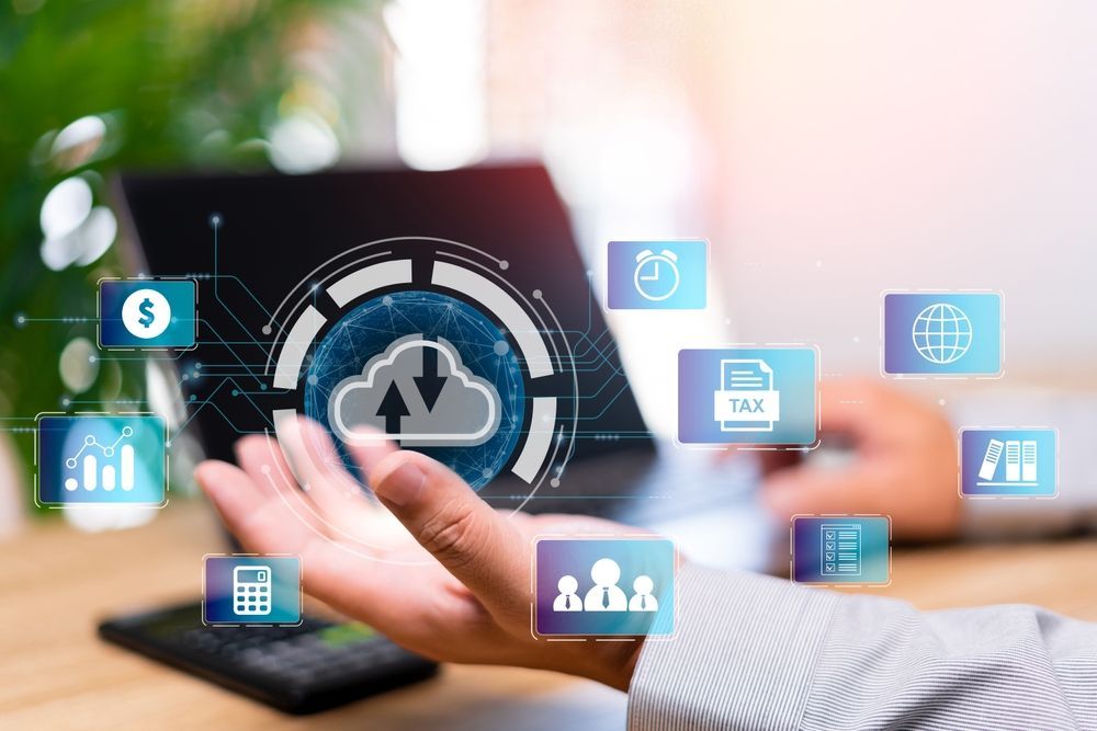 Person using a laptop, hand out with cloud technology interface with various icons.