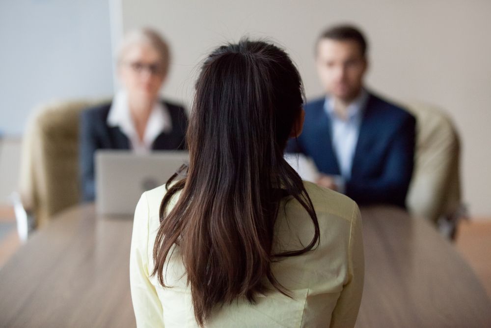 Woman in Yellow Shirt at Interview Table — Umbrella Legal in Cardiff, NSW