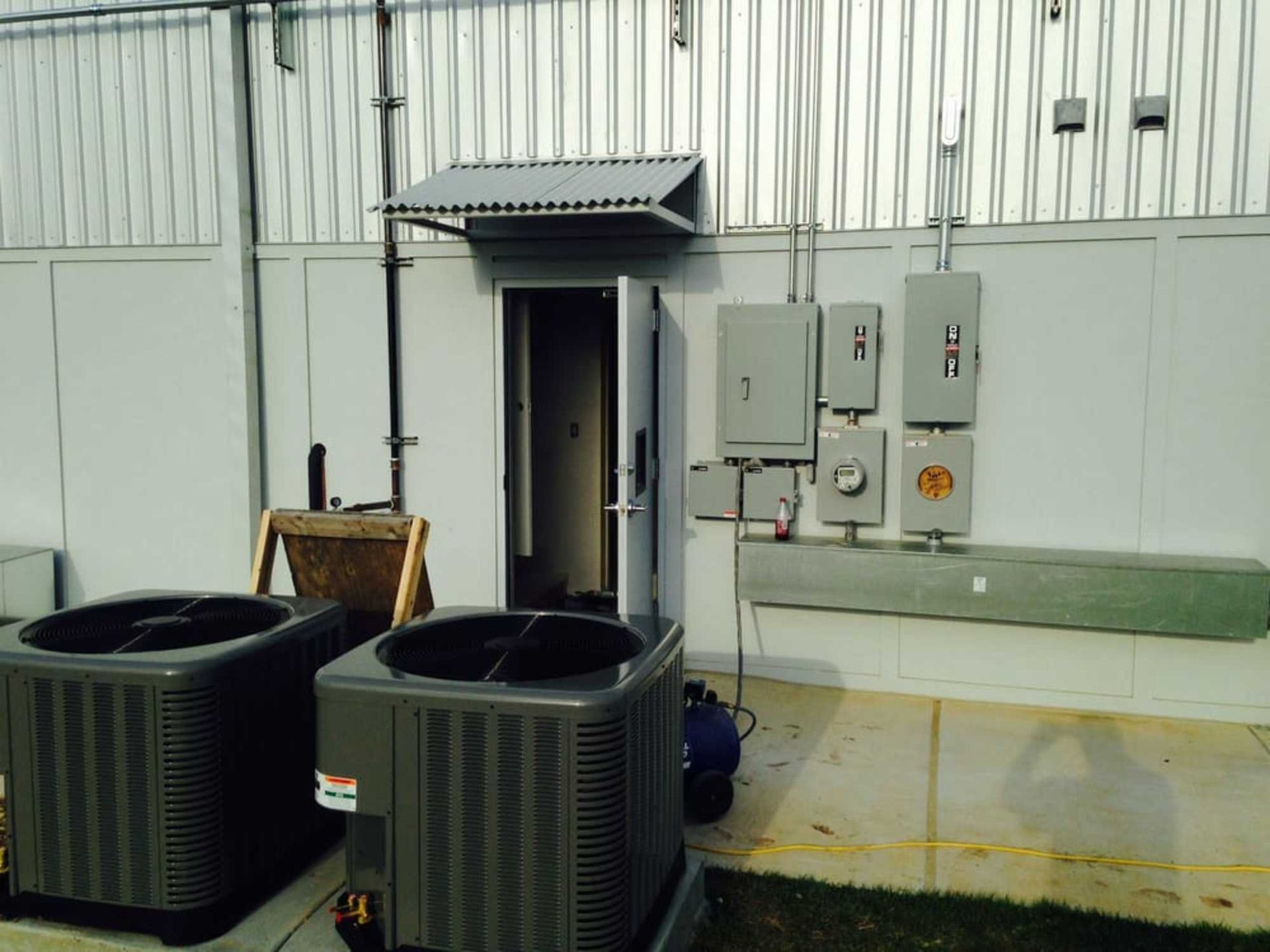 Two air conditioners are sitting outside of a building