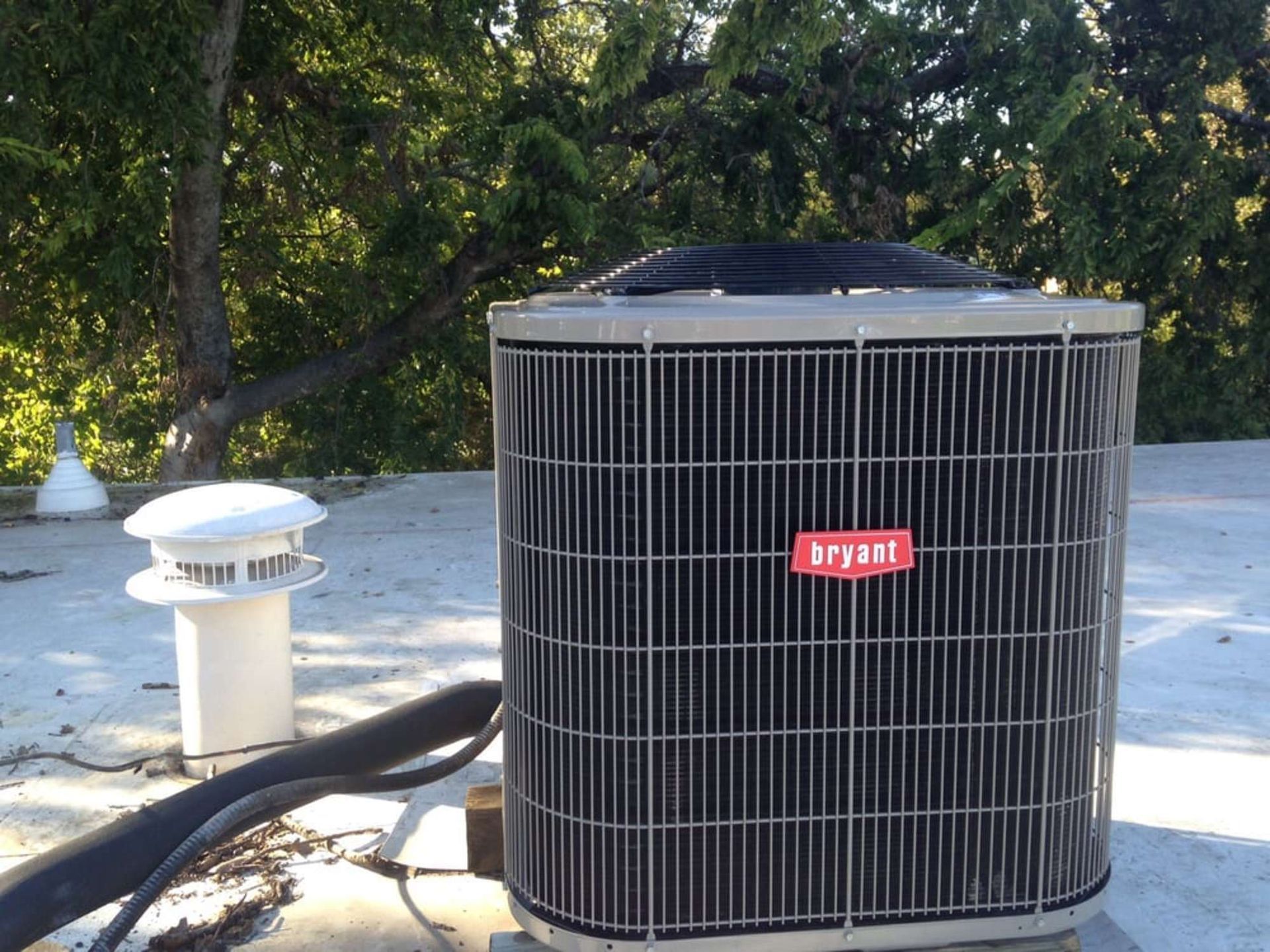 A bryant air conditioner is sitting on top of a roof
