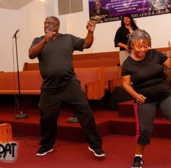 A man and a woman are dancing in front of a sign that says pat