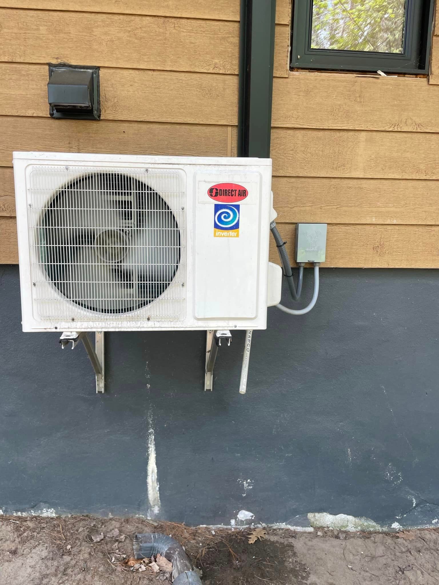 Un climatiseur blanc est monté sur le côté d'un bâtiment.