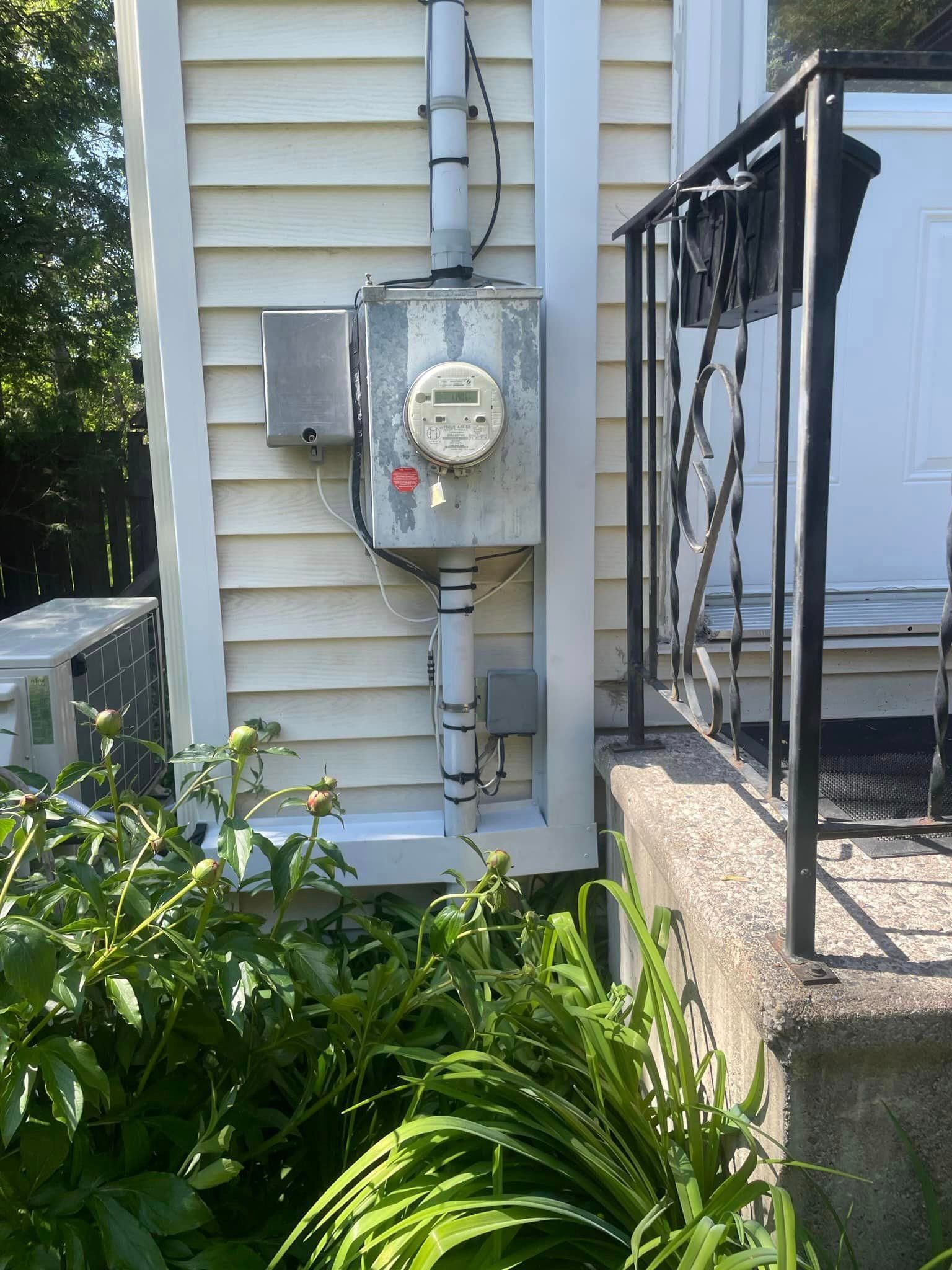 Une maison blanche avec un compteur sur le côté