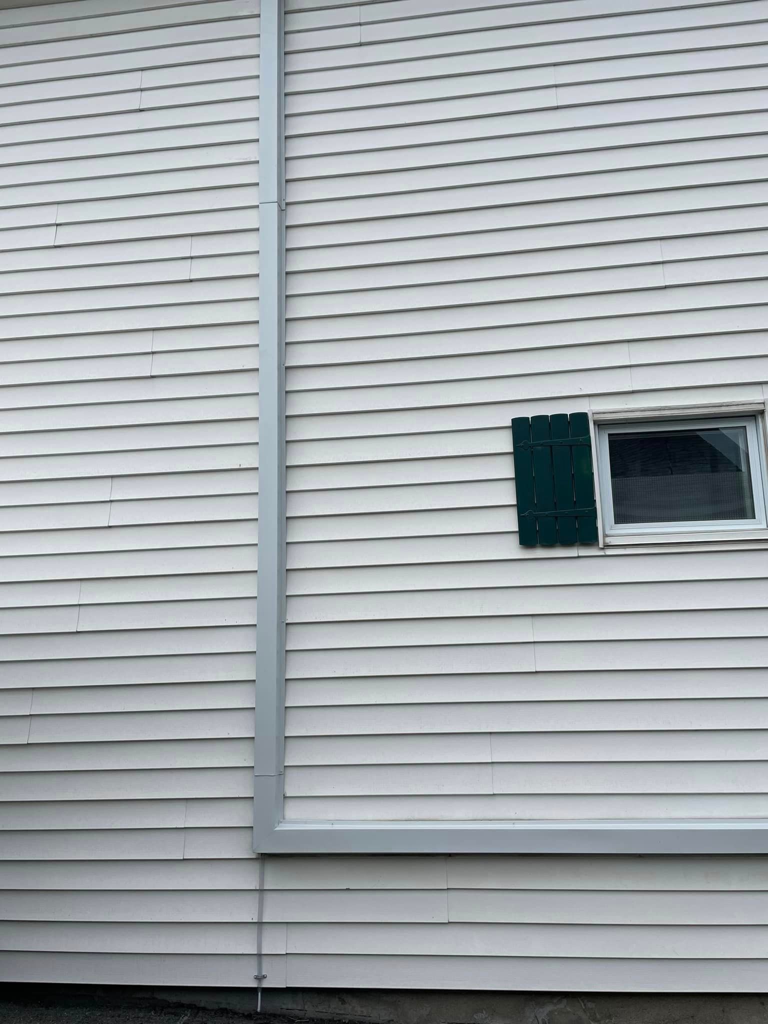 Une maison blanche avec une fenêtre sur le côté.