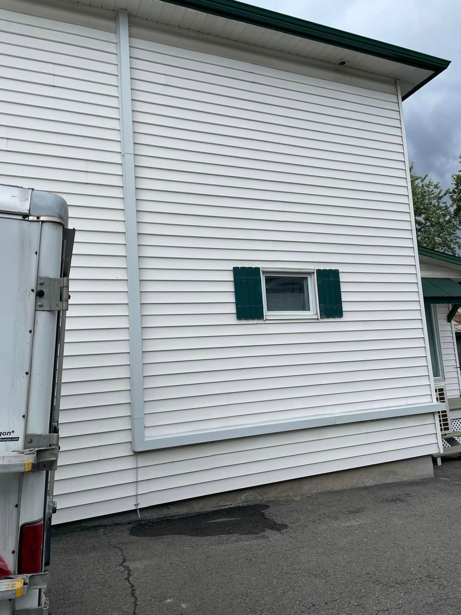 Une maison blanche avec une caravane garée devant