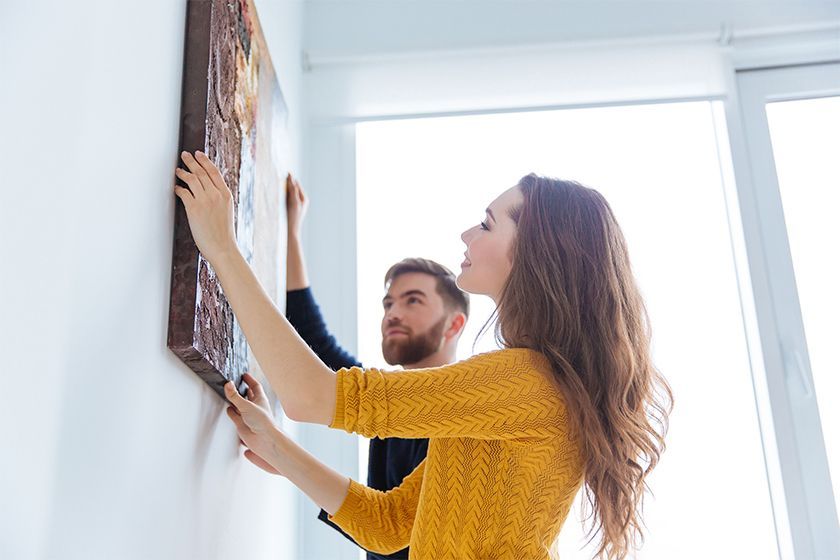 A person holding a frame and a picture with flowers on it