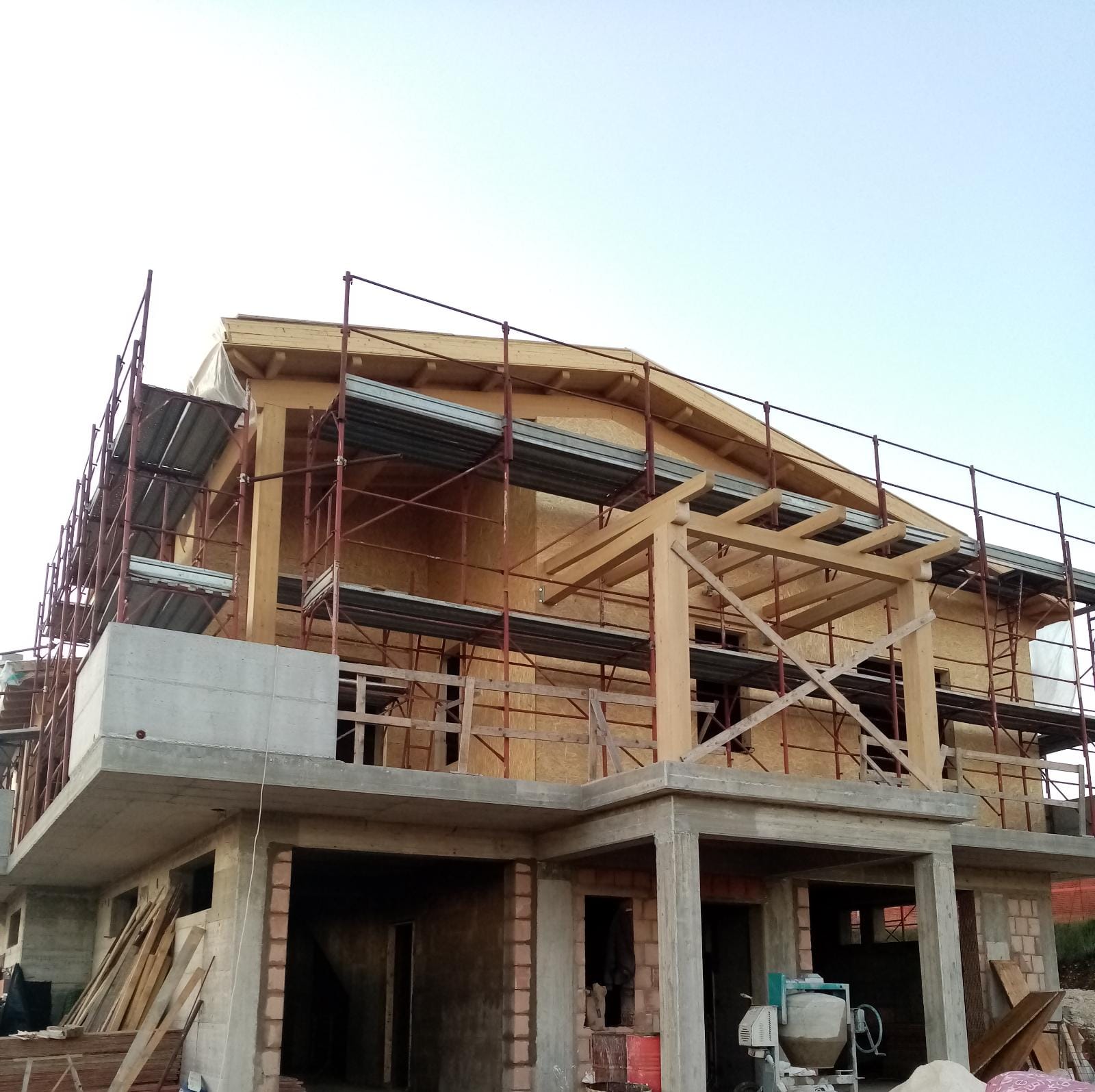 Una casa in costruzione con impalcature e una betoniera
