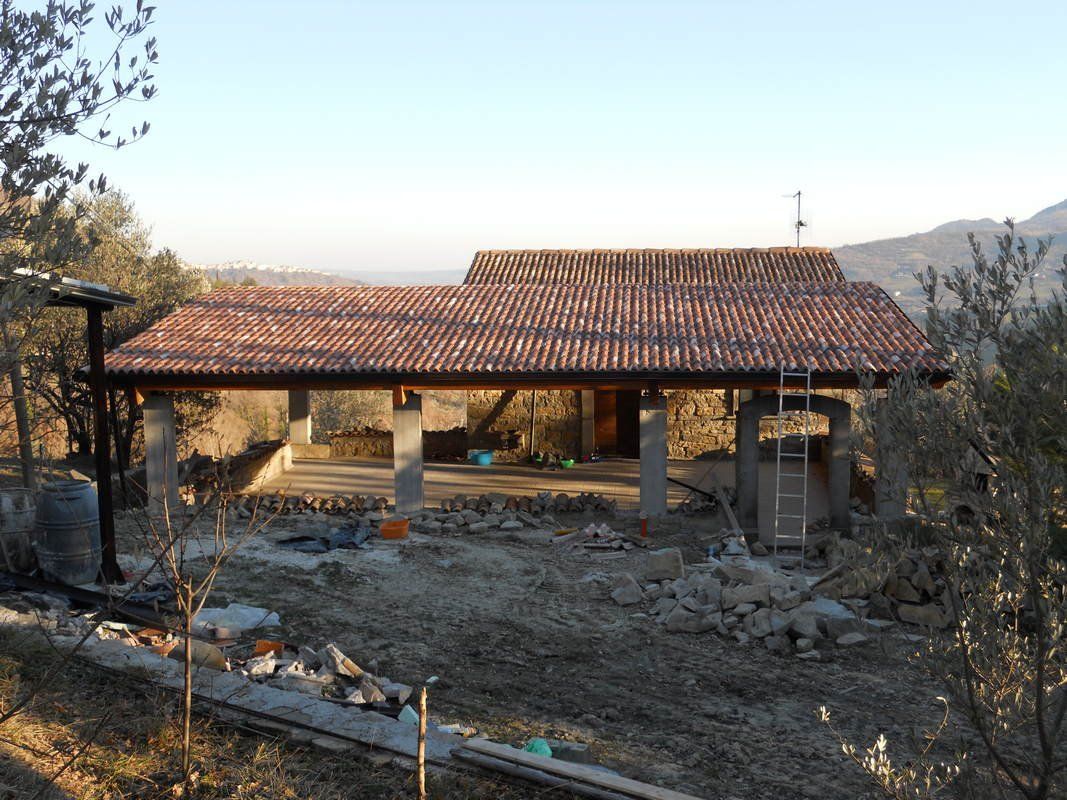 In mezzo a un campo viene costruita una casa con il tetto di tegole.
