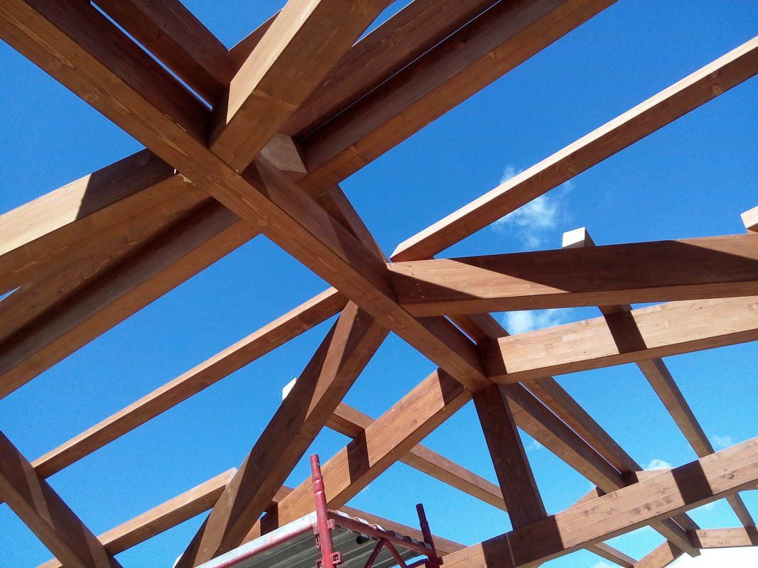 Guardando in alto verso una struttura in legno con un cielo azzurro sullo sfondo