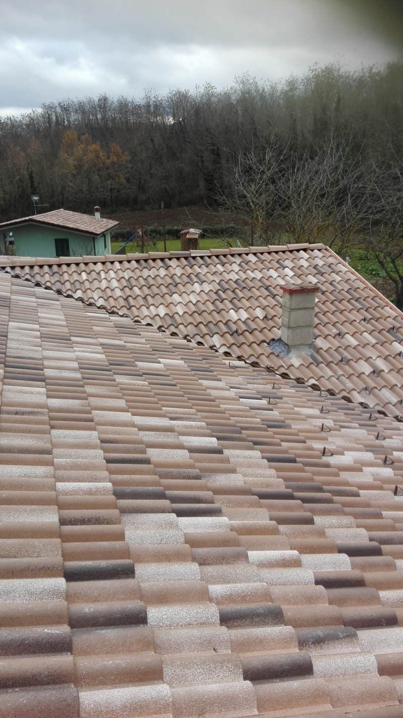 Un primo piano di un tetto di tegole con un camino in cima.
