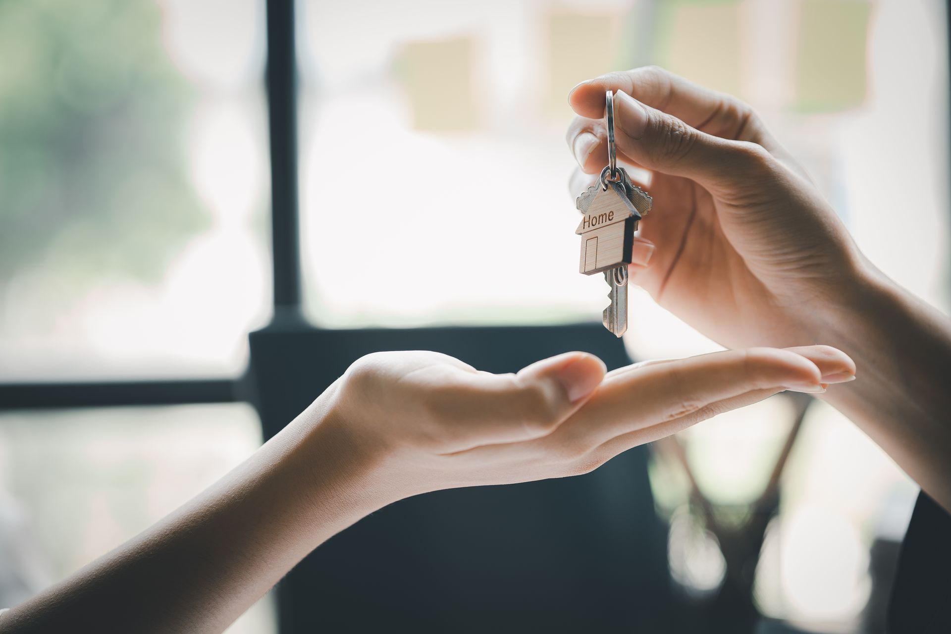 A man and a woman are walking in front of a house holding hands.