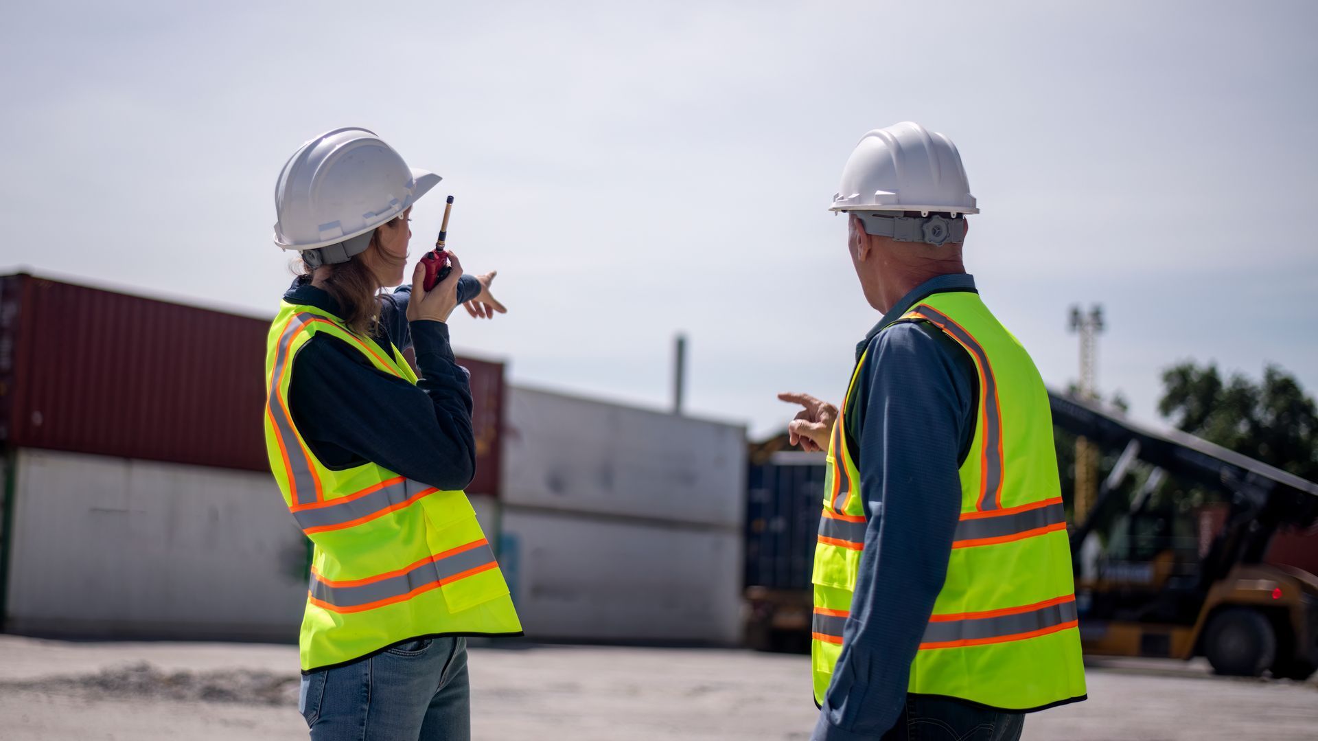 A family is sitting on the porch of their house next to a swimming pool.