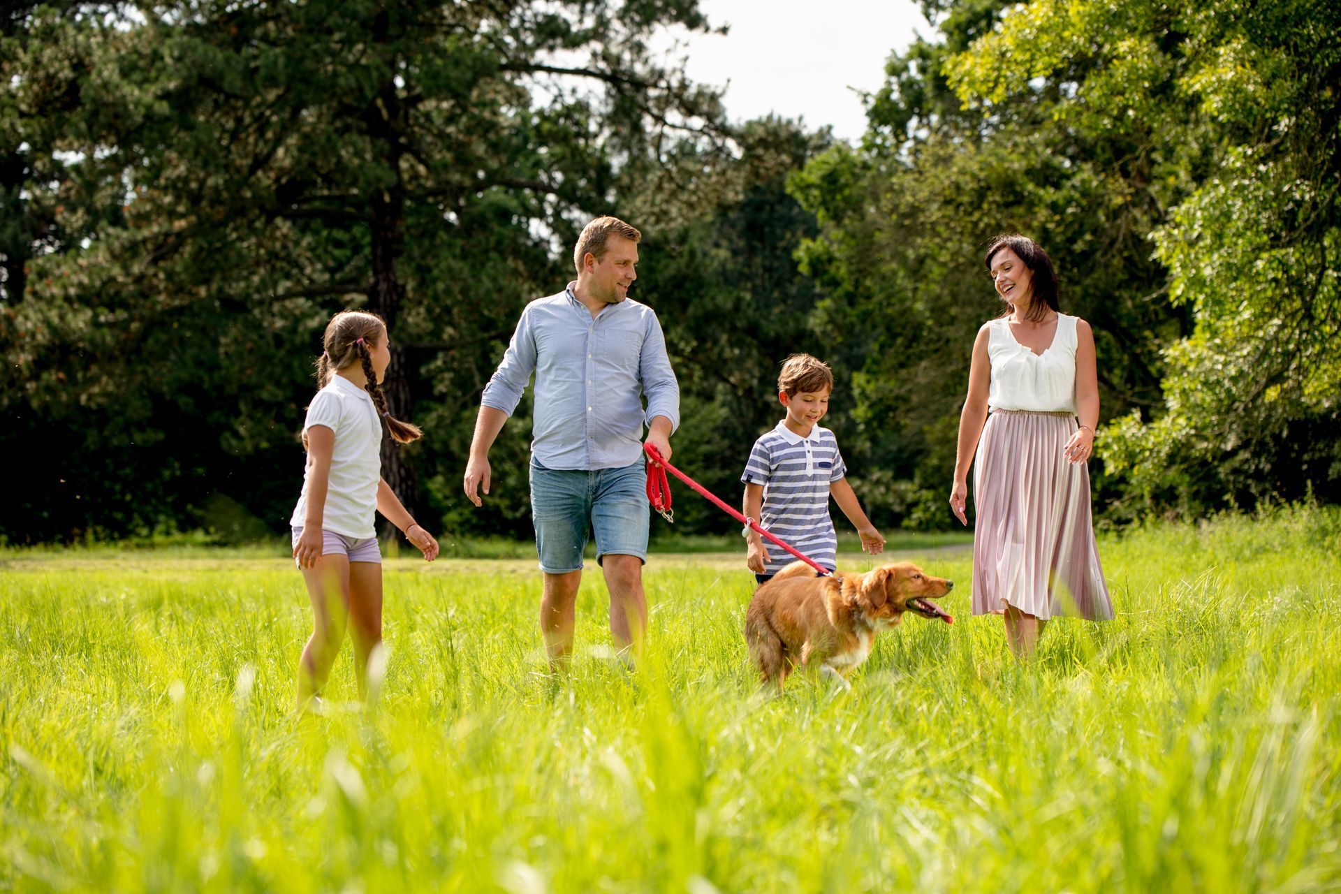 A family is moving into a new home carrying boxes.