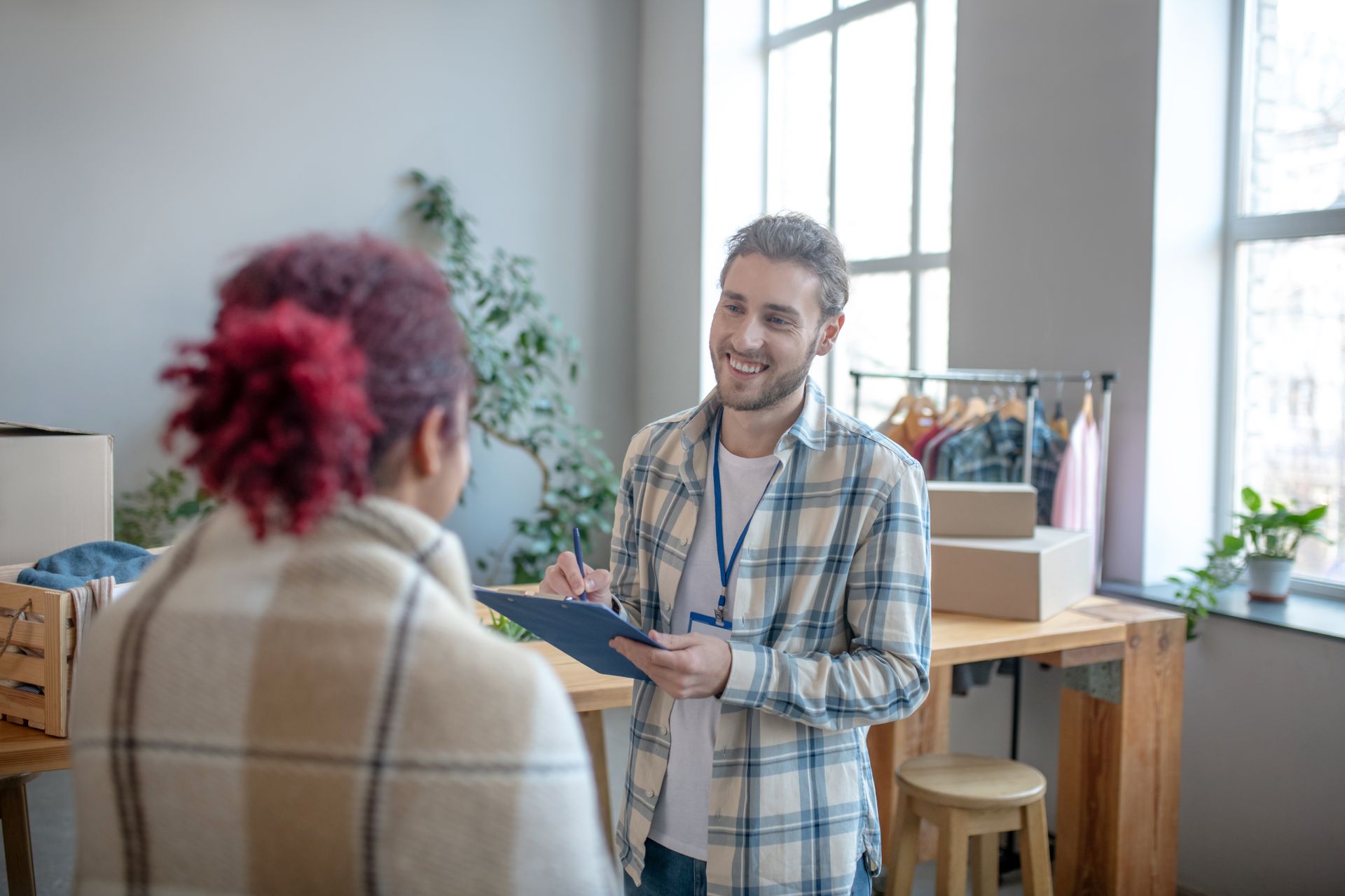 A man and a woman are walking in front of a house holding hands.