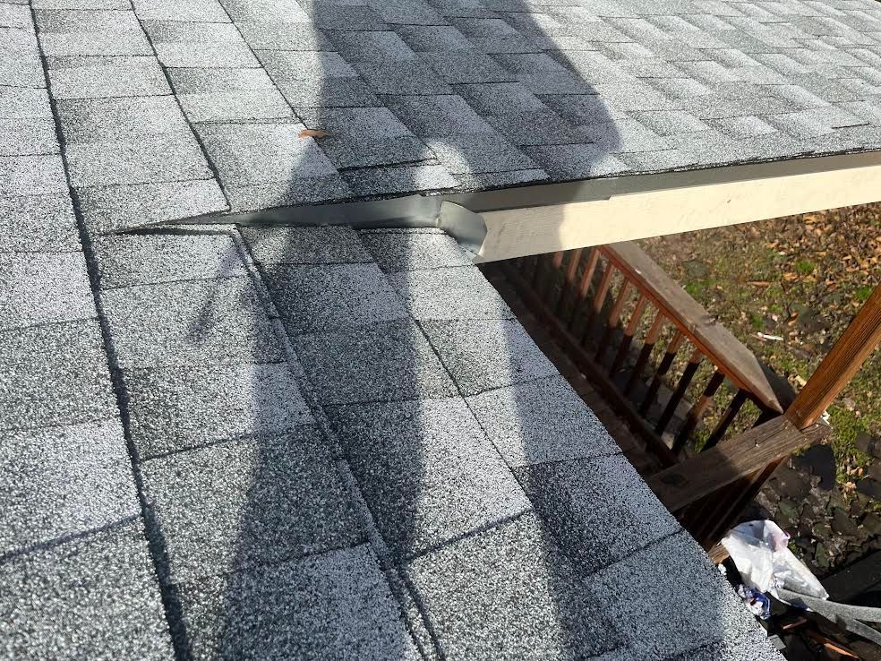 A close up of a roof with a shadow of a person on it.
