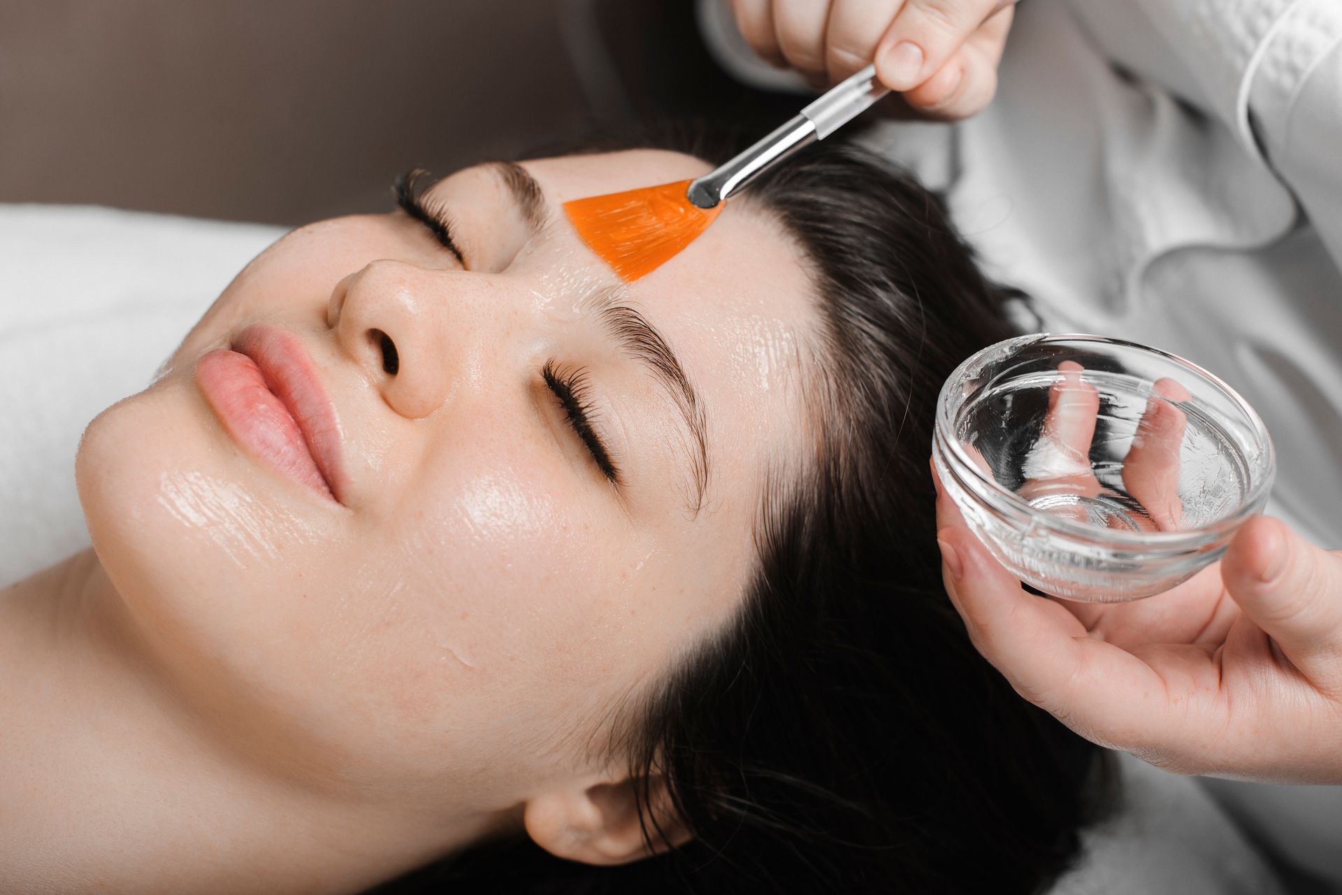 A woman is getting a facial treatment at a beauty salon.