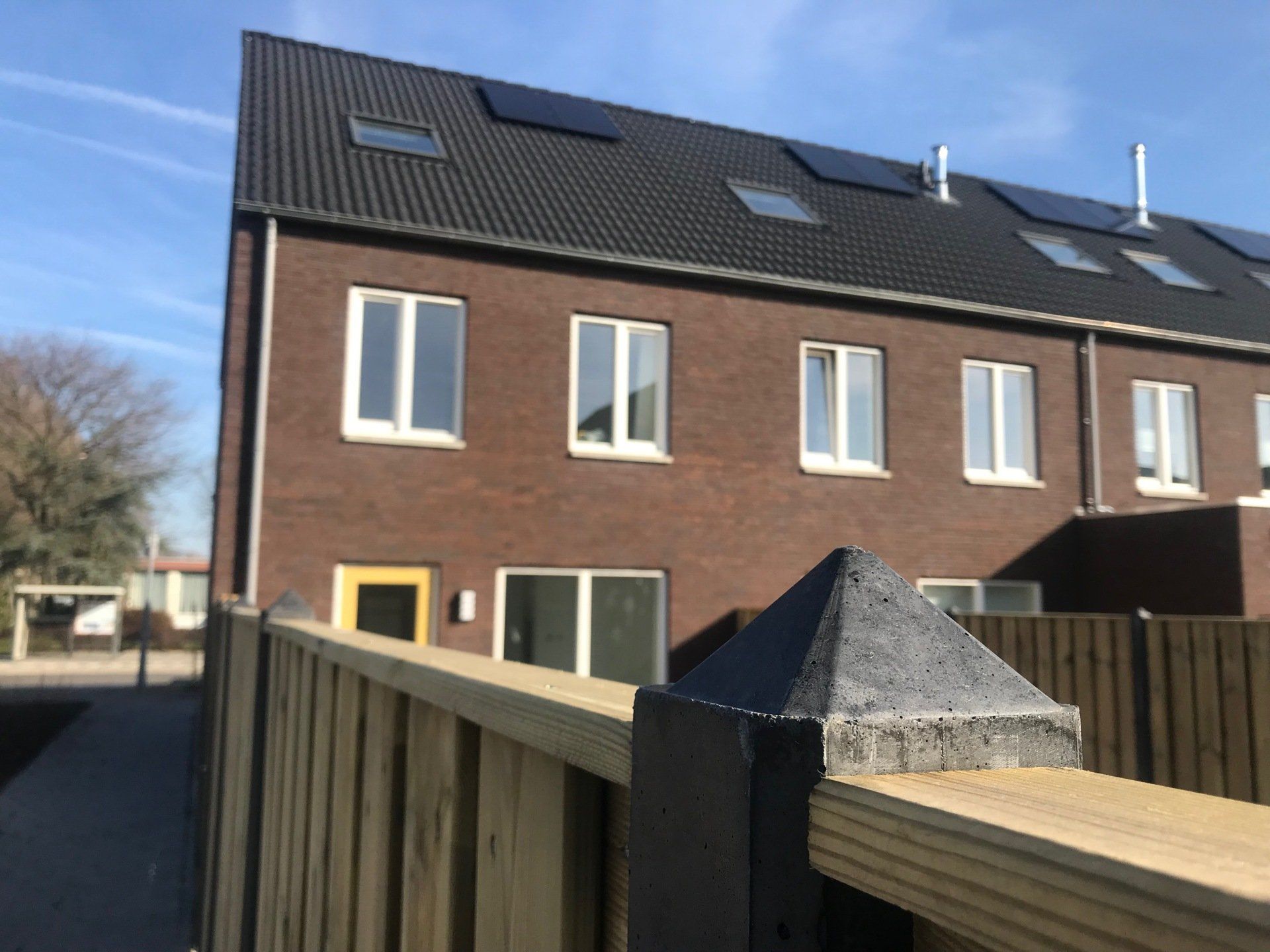 Een bakstenen gebouw met een houten hek ervoor