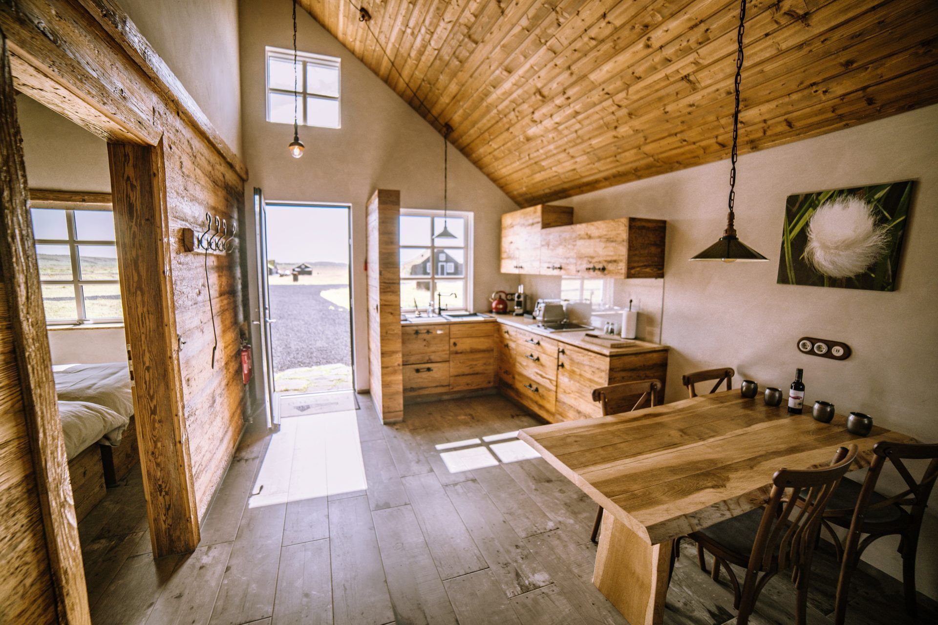 A kitchen with a wooden table and chairs and a vaulted ceiling.