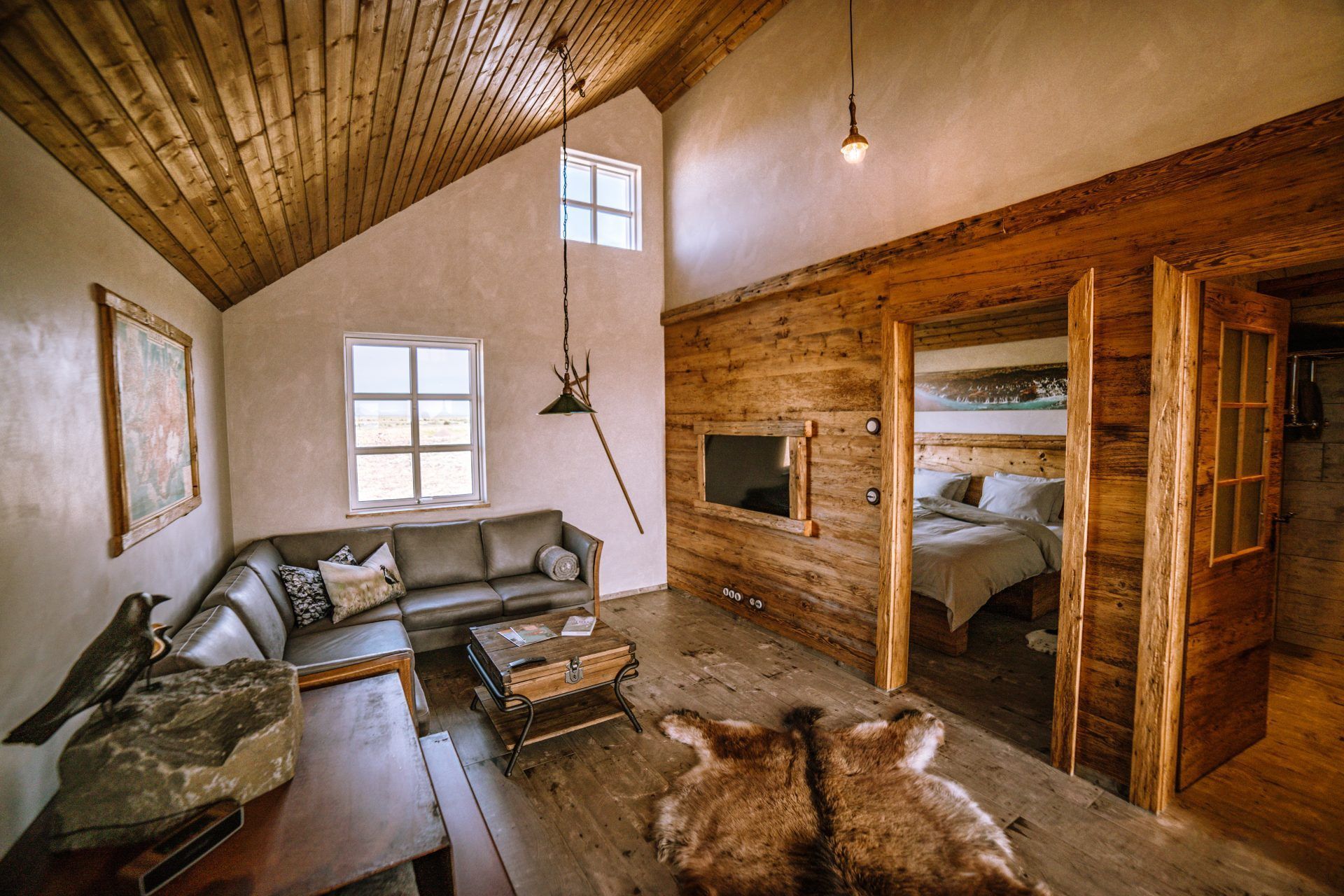 A living room with a couch , table , rug and a bed.