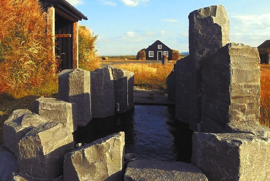 A house is in the background behind some rocks