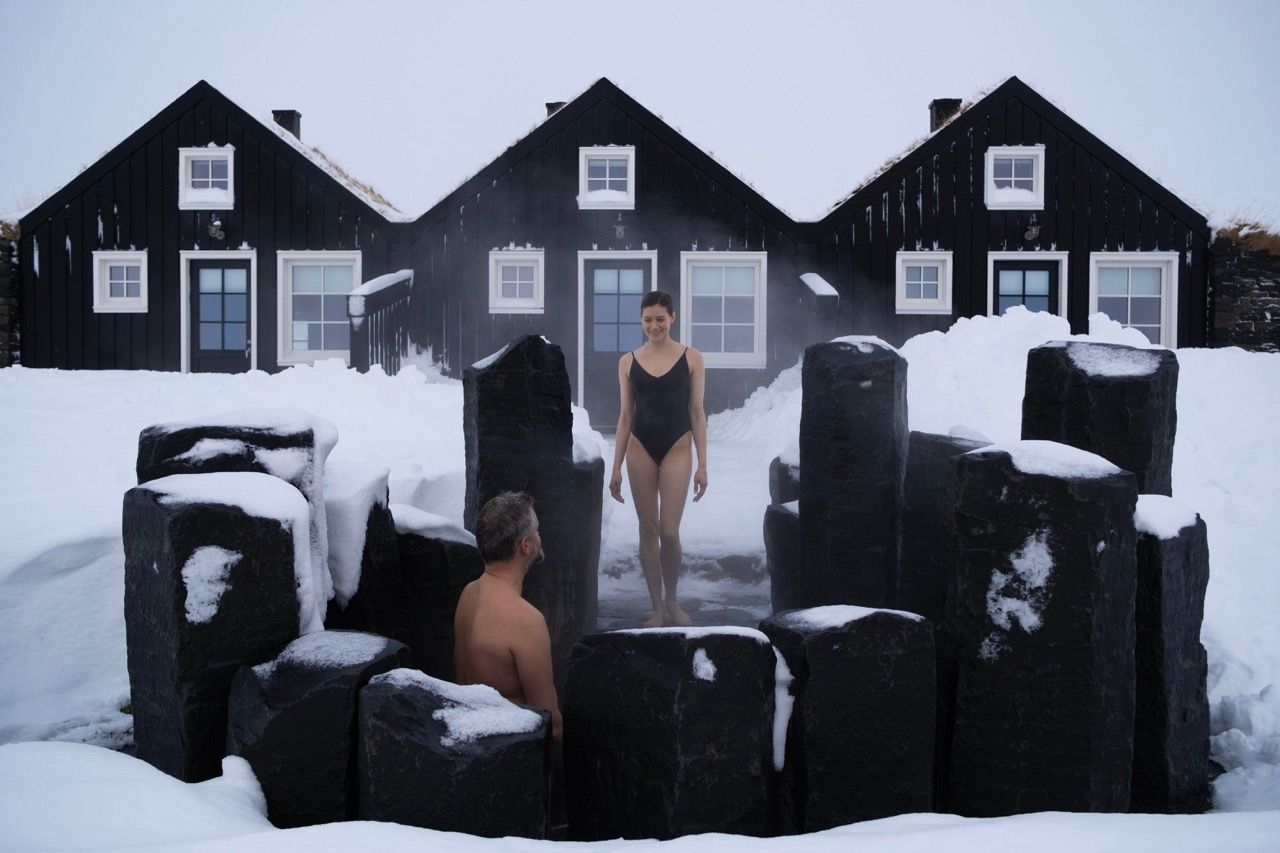 A house in the middle of a field at sunset.