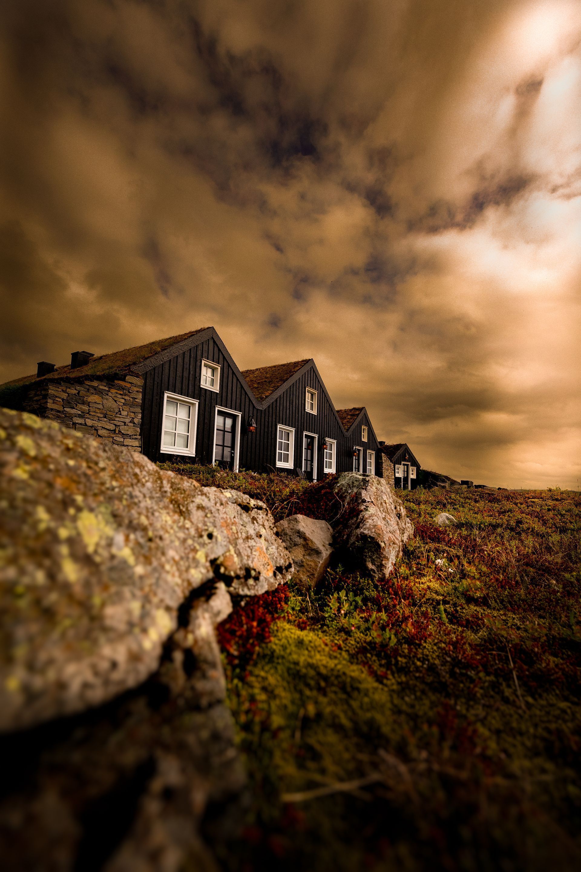 A row of houses are sitting on top of a rocky hill.