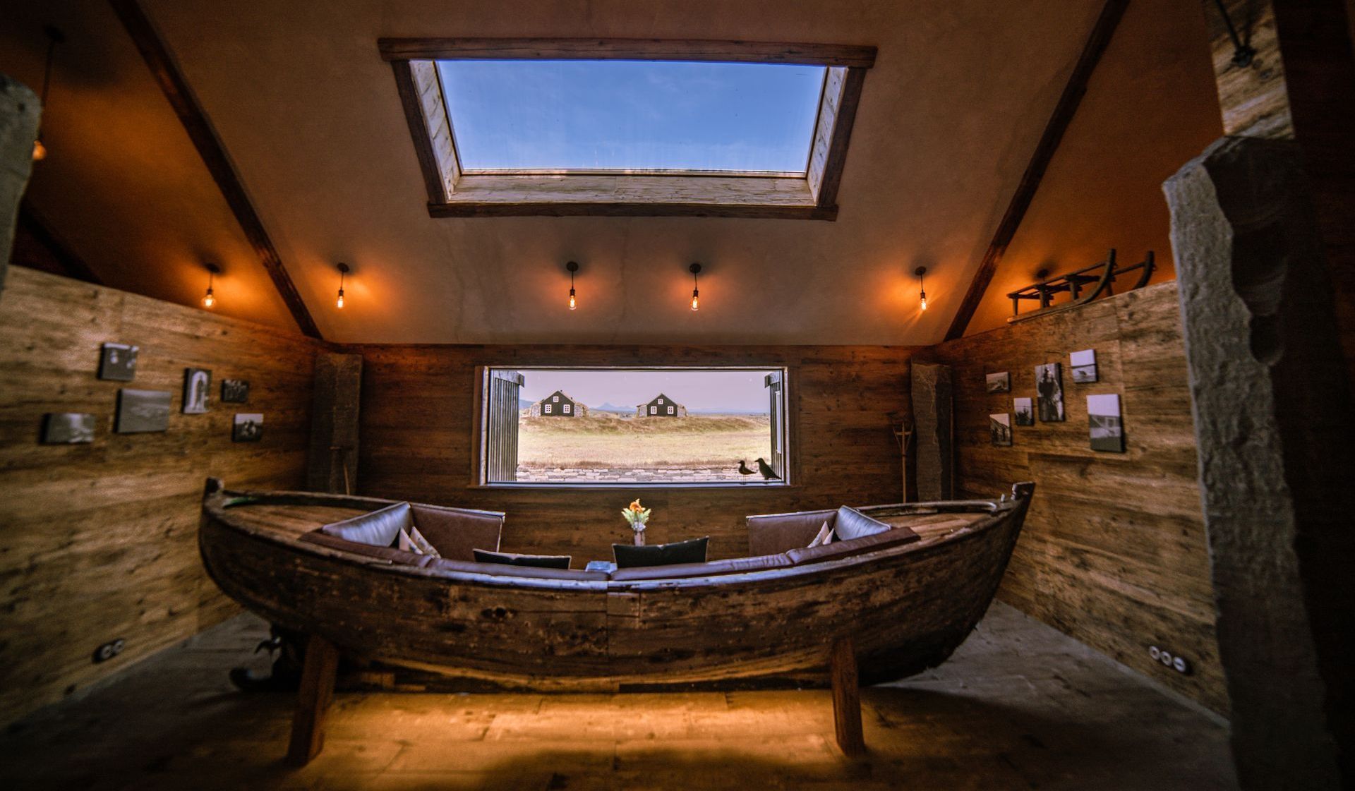 There is a boat in the middle of the room with a skylight above it.