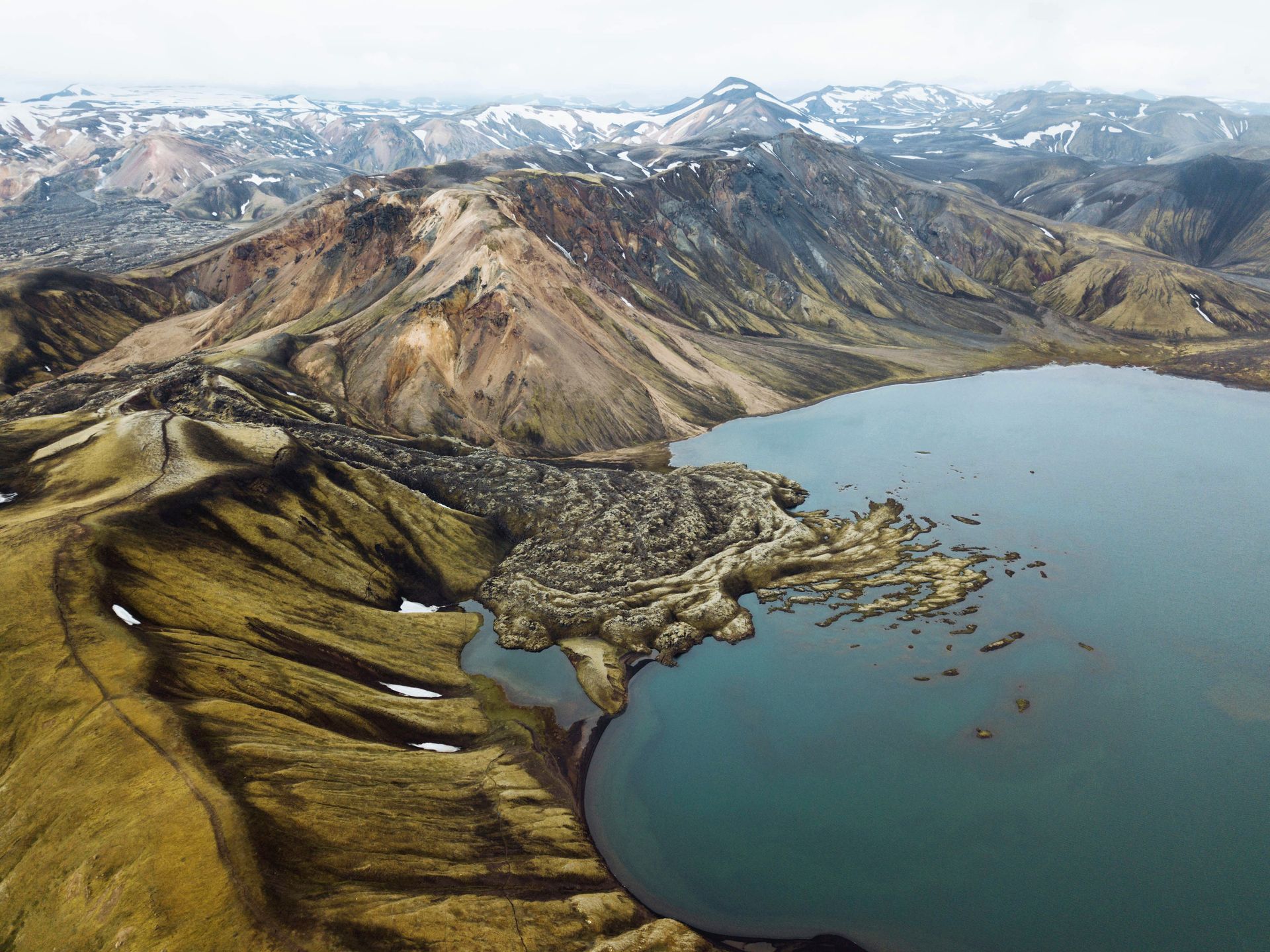 An aerial view of a lake surrounded by mountains.
