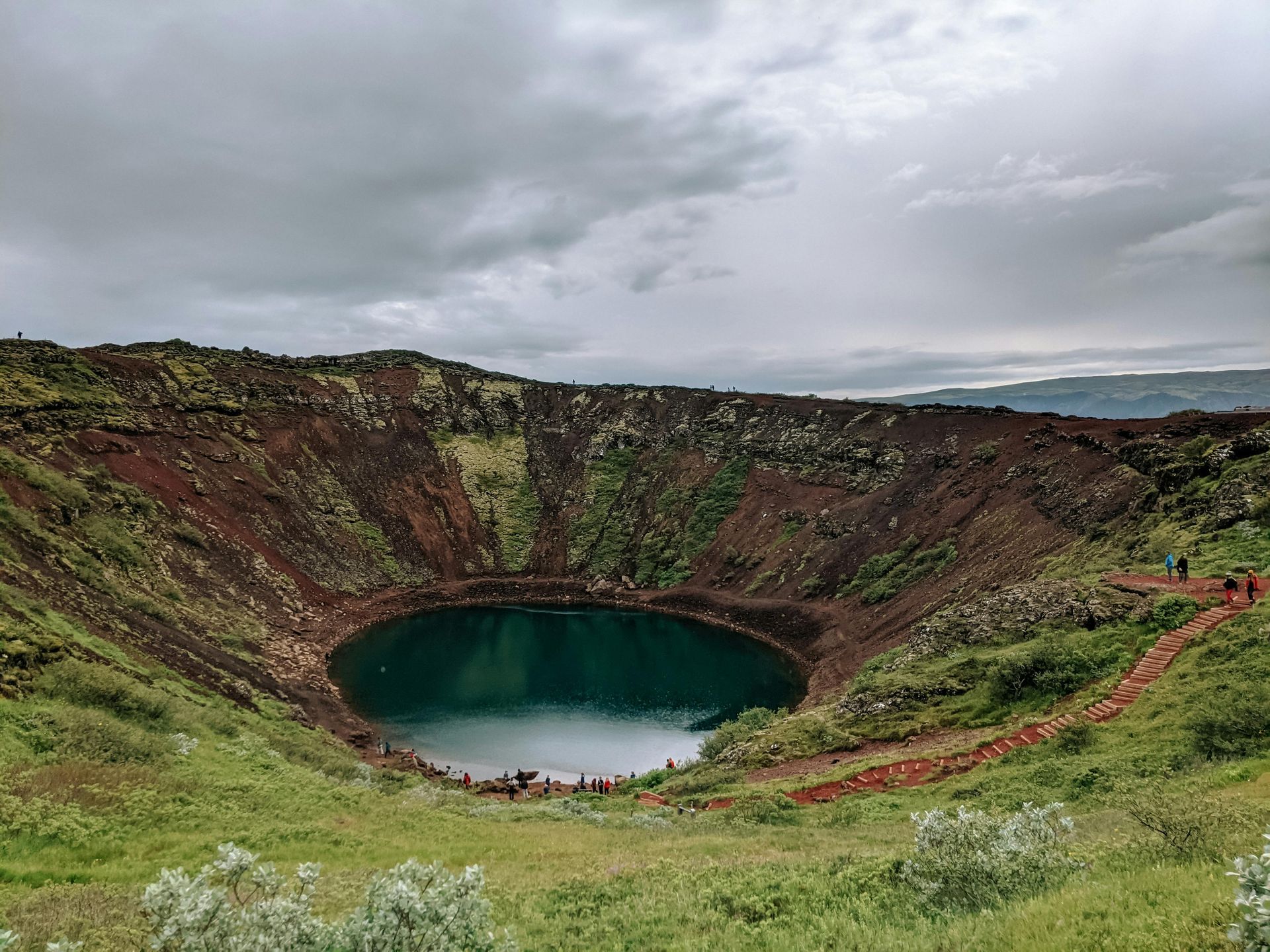 A large hole in the ground with a lake in the middle of it.