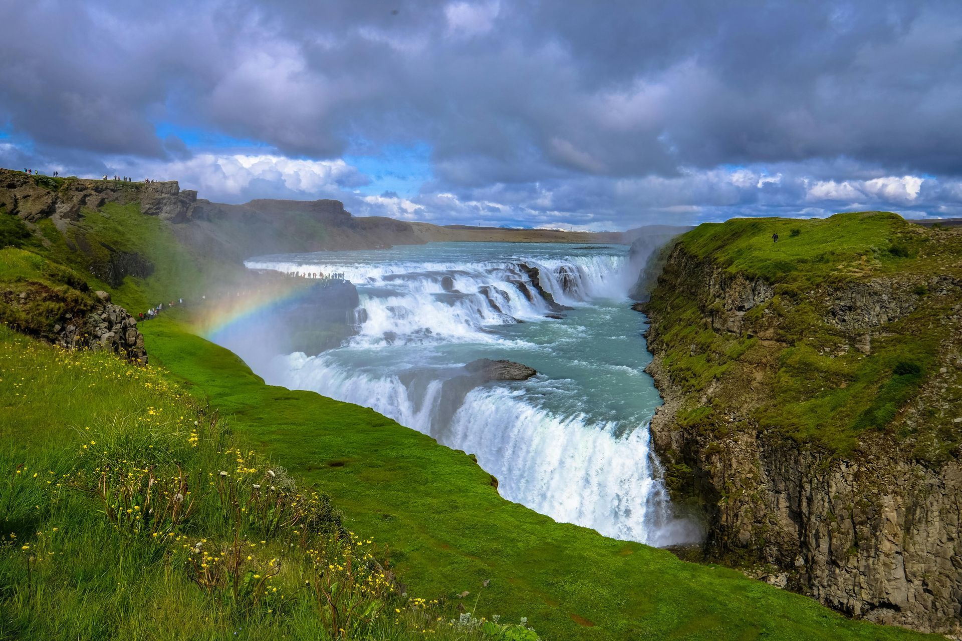 A waterfall with a rainbow in the middle of it
