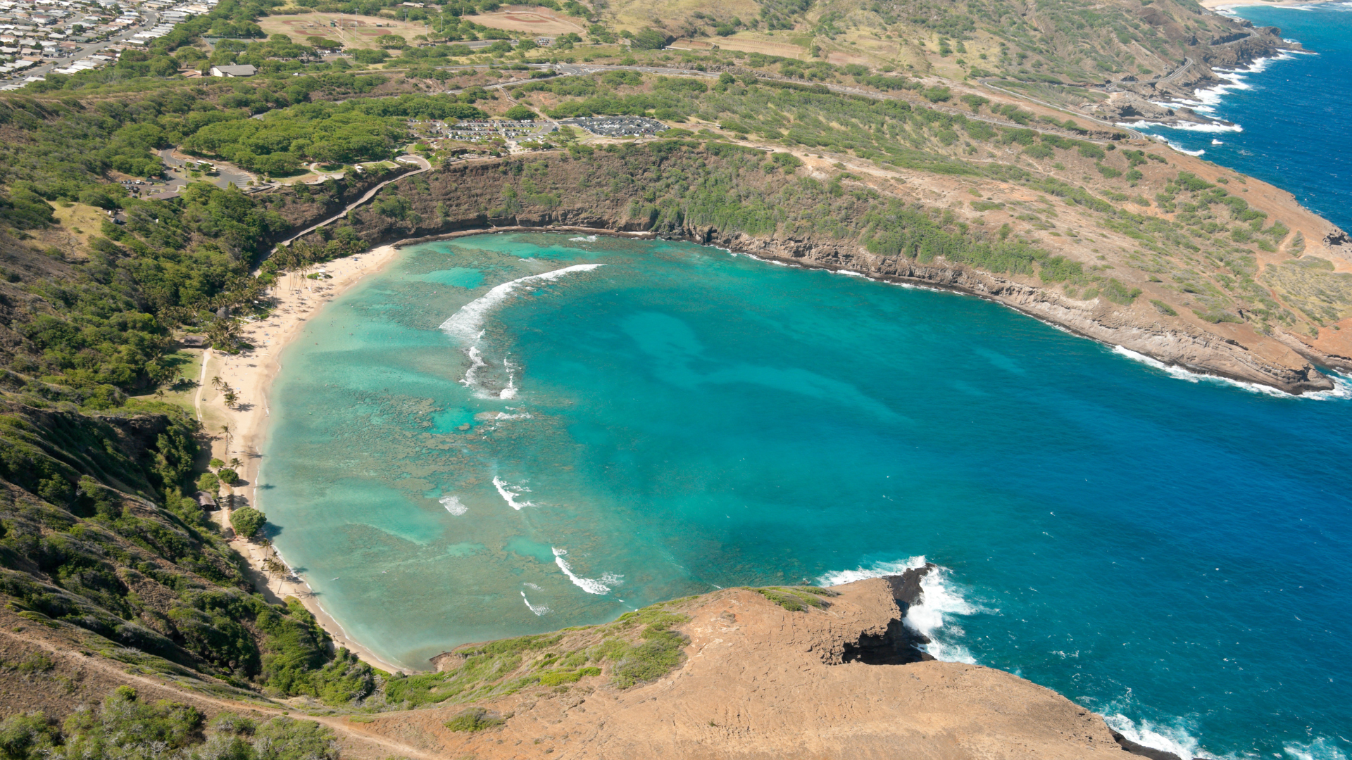 An aerial view of a large body of water surrounded by mountains and trees.