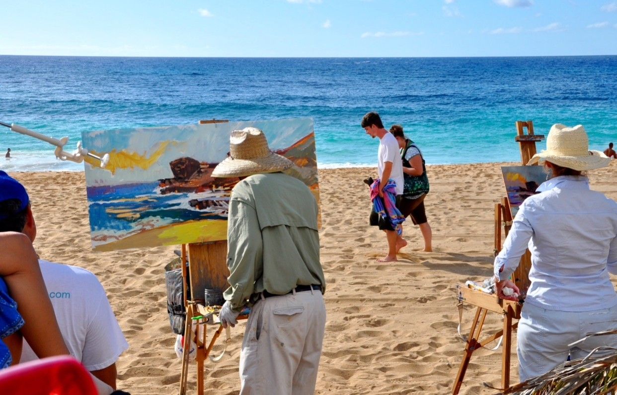 A group of people are painting on the beach