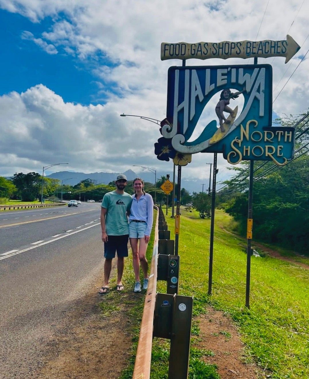 A couple standing in front of a sign that says haleiwa north shore