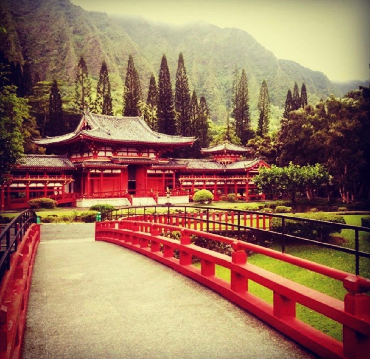 A bridge leading to a temple with mountains
