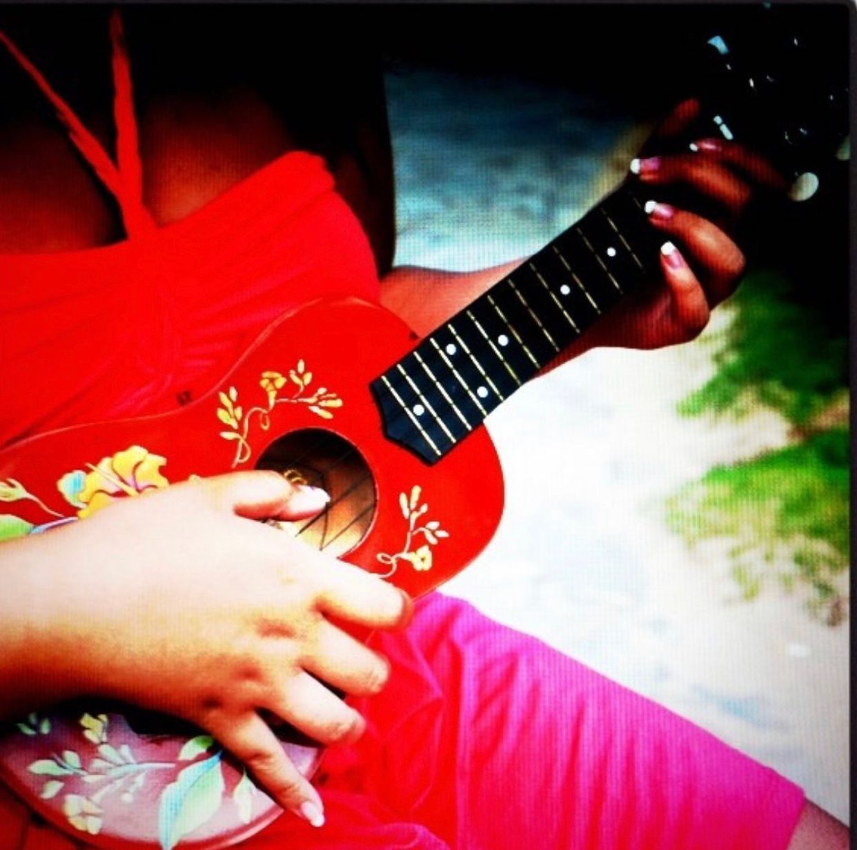 A woman wearing a lei is dancing on the beach.