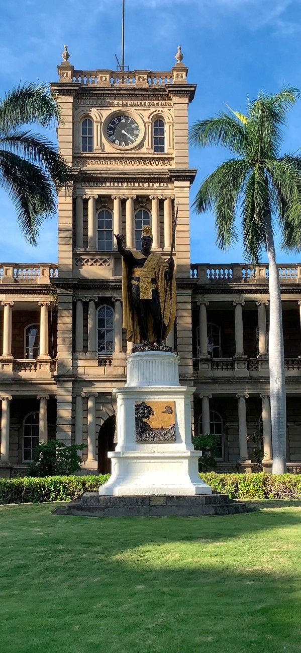A large building with a clock tower and a statue